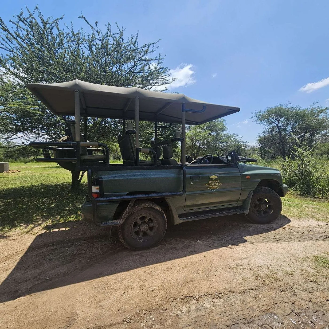 Rupping Bush Retreats branded open-top game viewer vehicle parked in the bush