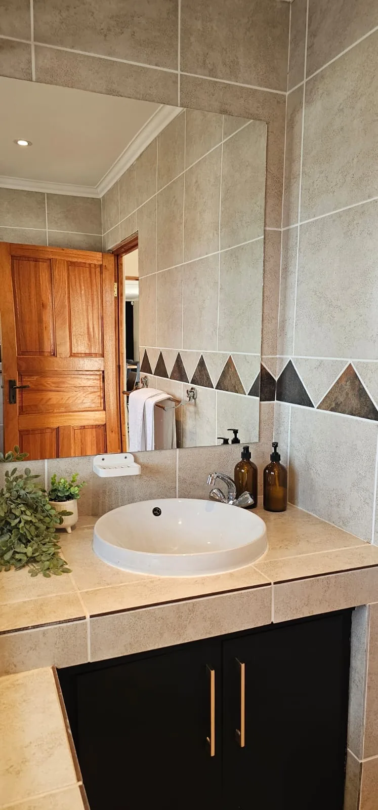 Bathroom vanity with round basin, mirror and amber glass soap bottles