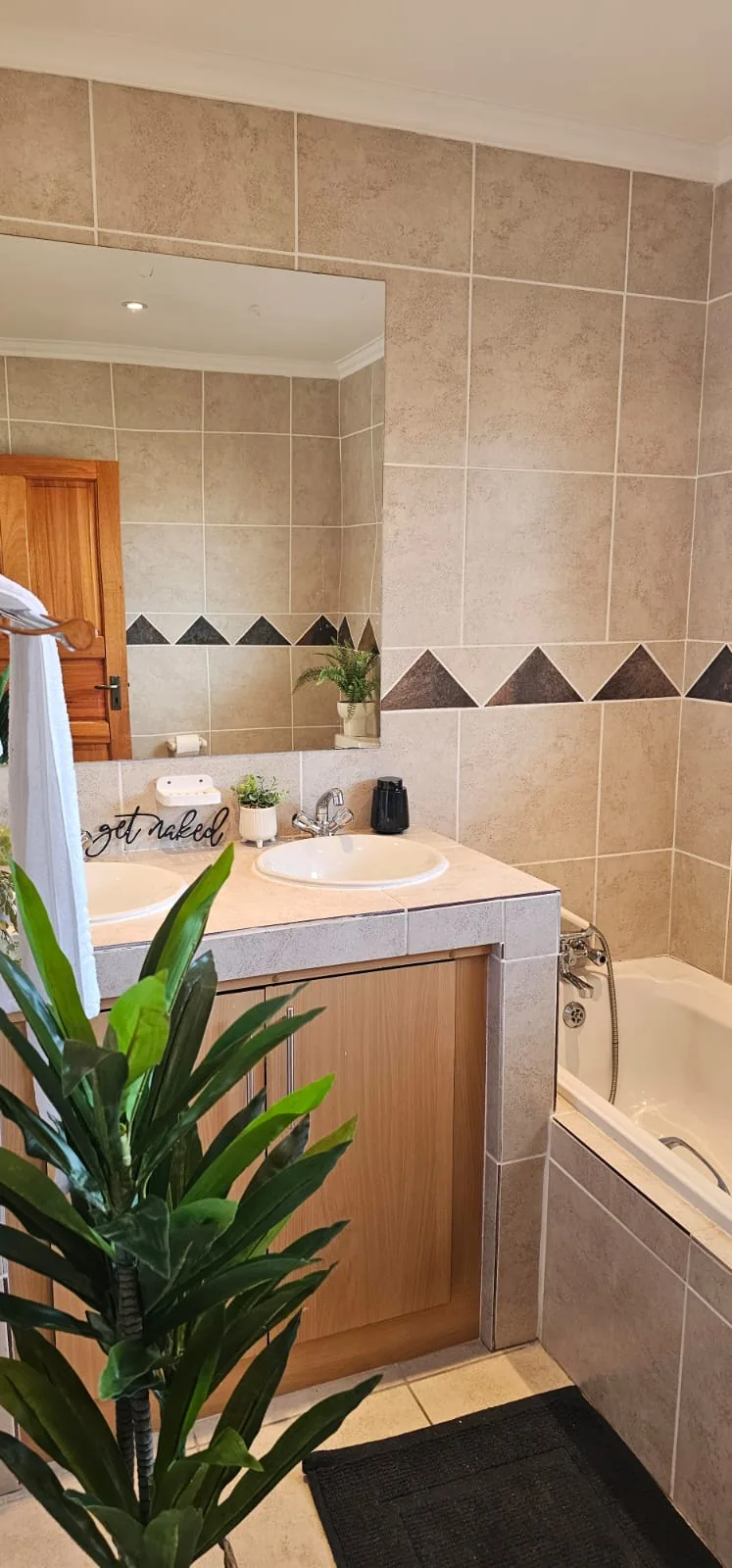 Bathroom vanity and bathtub with mirror, soap bottles and a hand-lettered sign